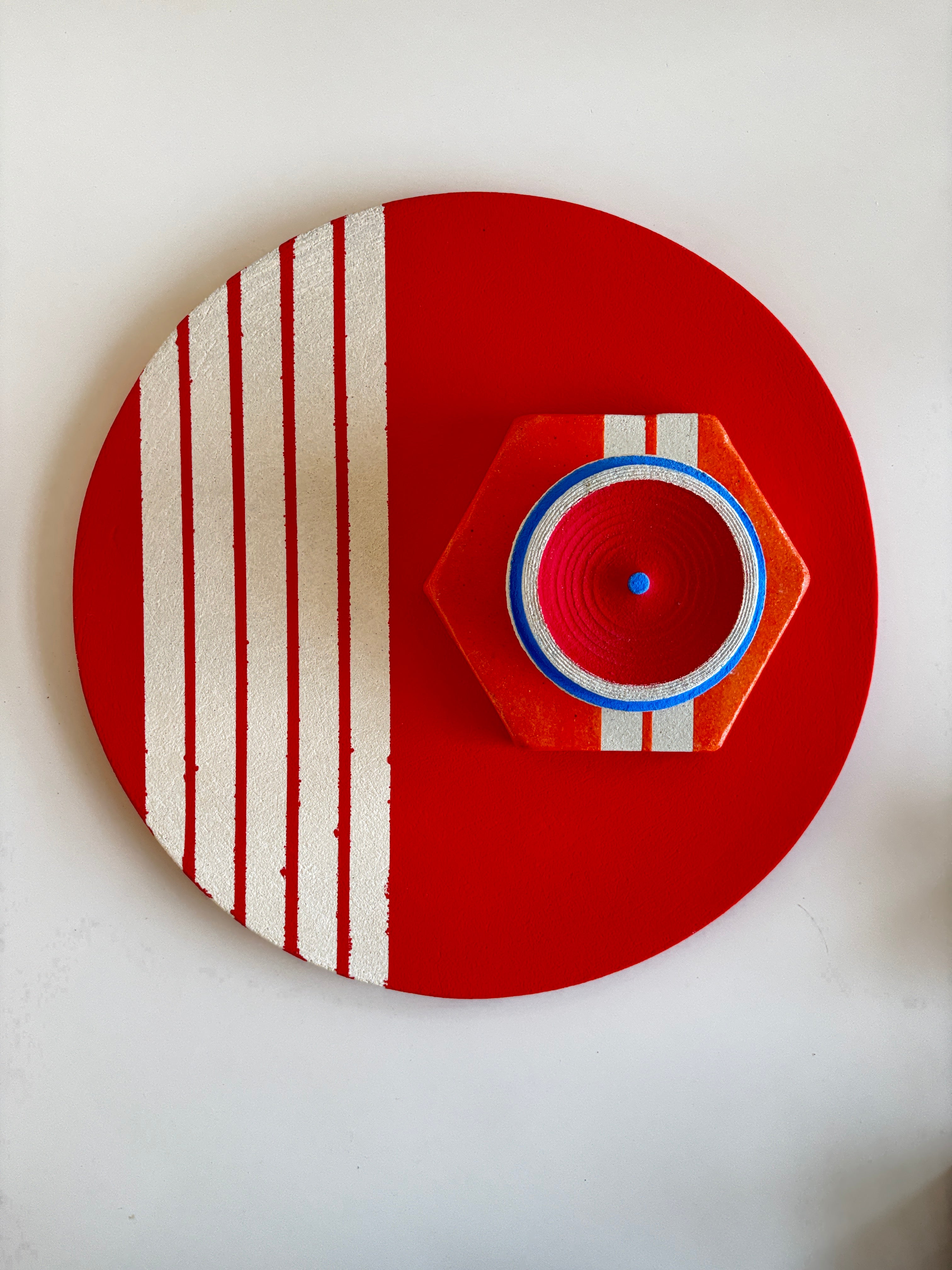 Decorative wall piece with red, white, and blue design on a white background